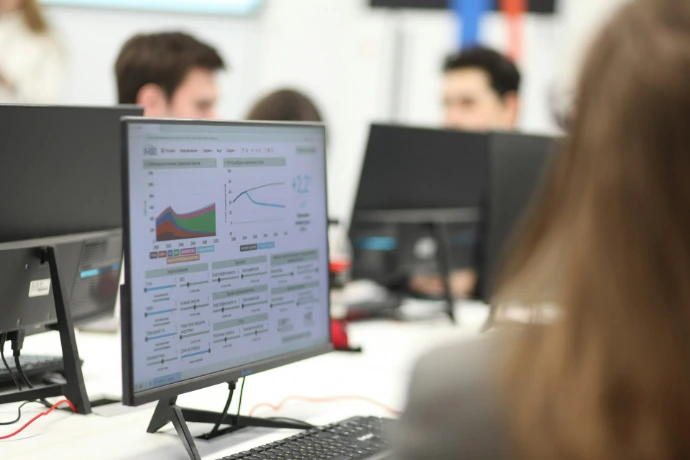 Een groep mensen die aan computers werkt in een kamer